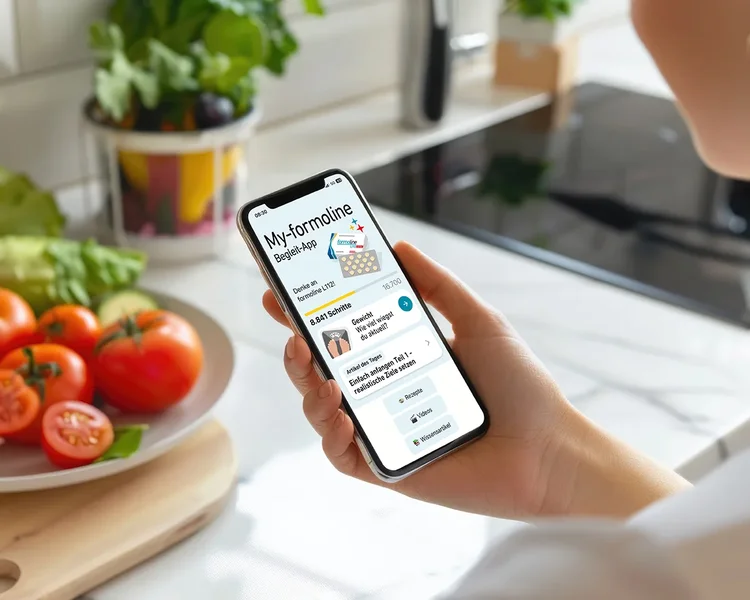 formoline App auf Smartphone Mensch benutzt formoline App auf dem Smartphone über Arbeitsfläche mit Gemüse