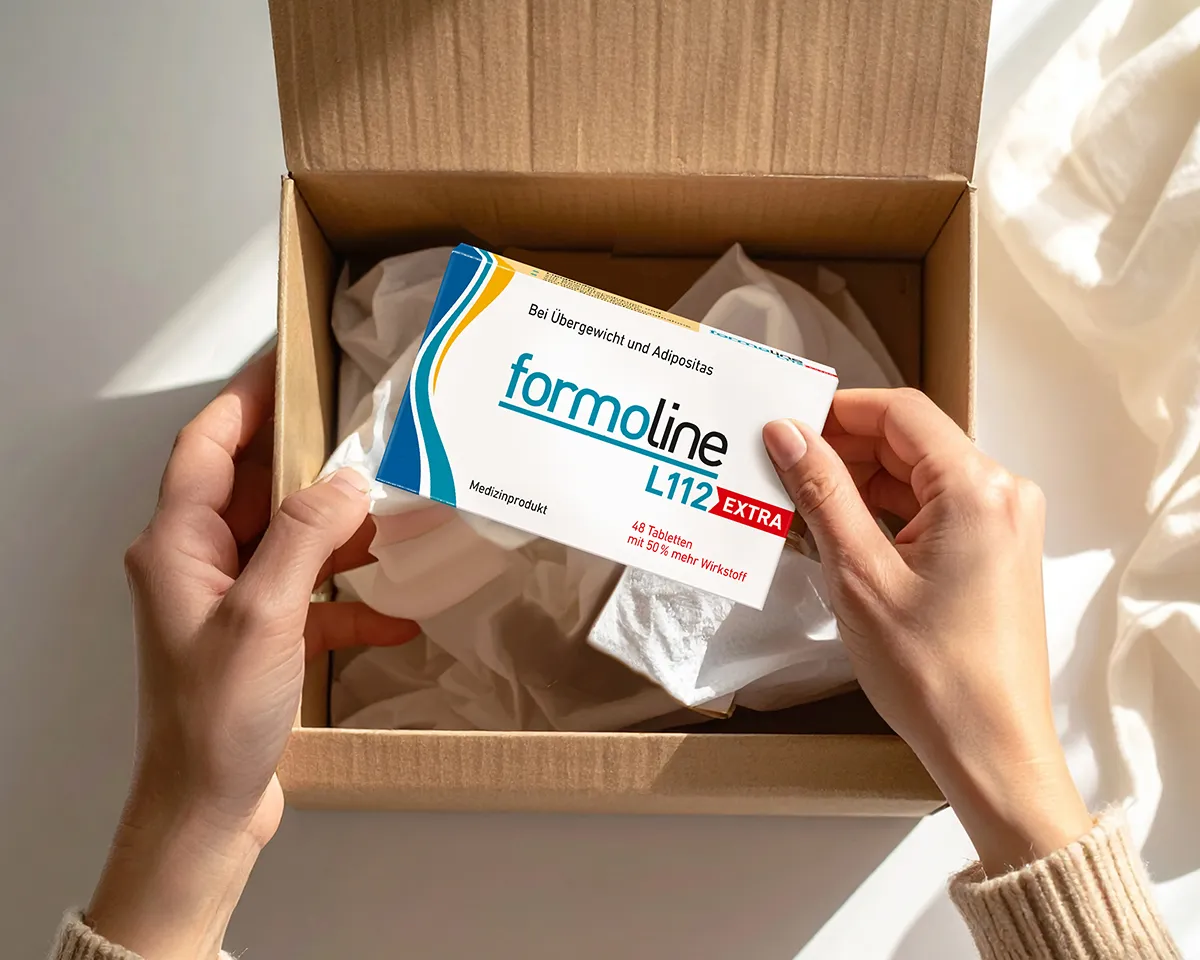 formoline L112 EXTRA in Versandkarton Hände halten formoline L112 EXTRA Packung über offenem Versandkarton.